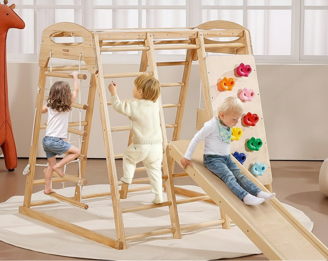 Children playing on a wooden play structure with a slide and climbing elements.