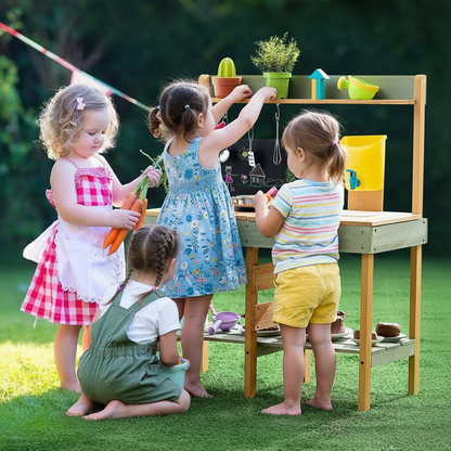 Children playing with a wooden play kitchen set outdoors on a grassy area.