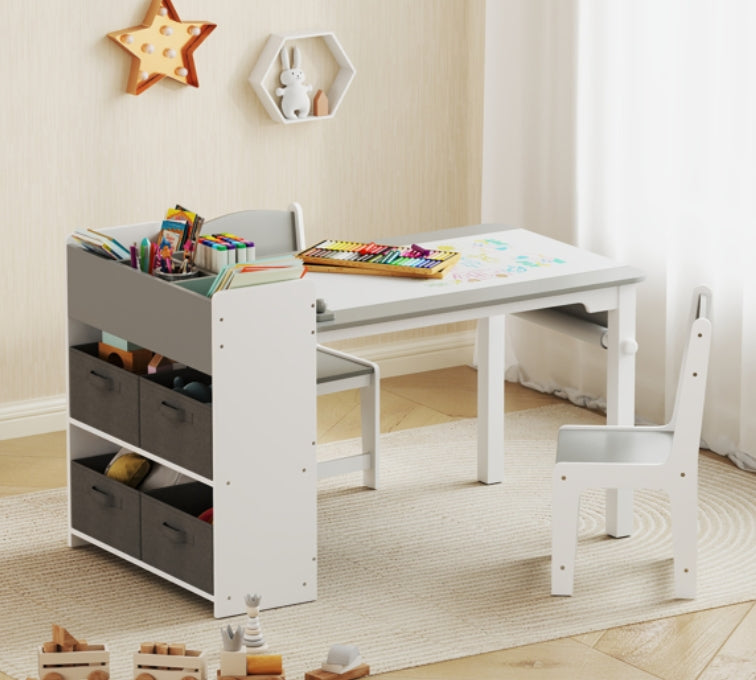 Children's play area with a white table and chairs, storage unit, and toys on a light wooden floor.