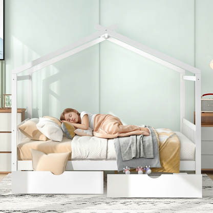 Child sleeping in a white house-shaped bed with a light green wall and wooden floor.