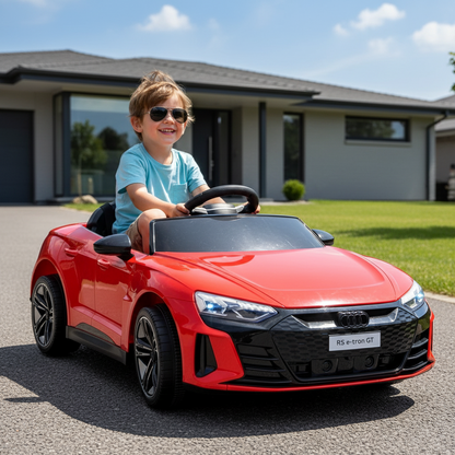 Child driving a red toy car on a driveway with a house in the background