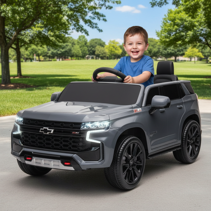 Child sitting in a toy car outdoors on a sunny day