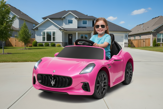 Child in a toy Maserati car in front of a house